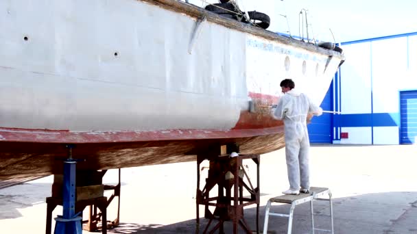 Worker paints metal of old rusty ship at shipyard in port of Moscow. — Stock Video