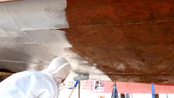 Lavoratore dipinge il fondo in metallo di nave a cantiere navale in porto di Mosca . — Video Stock