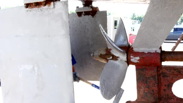 Worker paints metal of old rusty ship propeller at shipyard in port of Moscow. — Stock Video