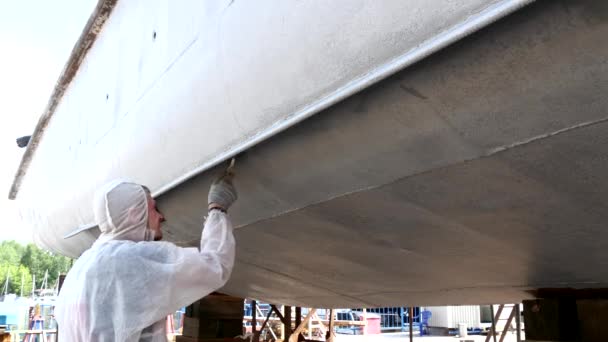 Pitture operaie con pennello fronte metallo di nave a cantiere navale in porto di Mosca . — Video Stock