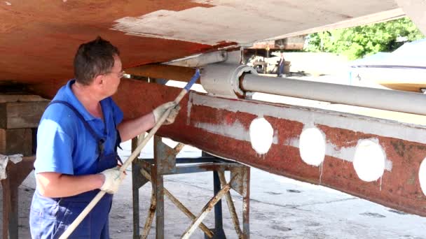 Pracovní maluje metal staré rezavé lodi v loděnici v přístavu v Moskvě. — Stock video