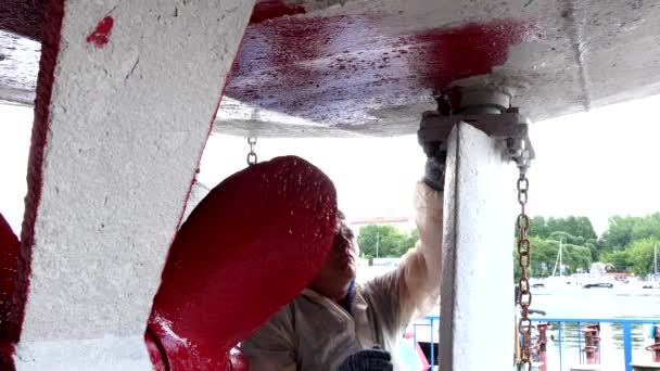 Lavoratore dipinge il metallo di elica di nave il colore rosso a cantiere navale in porto di Mosca . — Video Stock