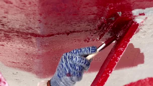 Worker paints metal of ship propeller red color at shipyard in port of Moscow. — Stock Video