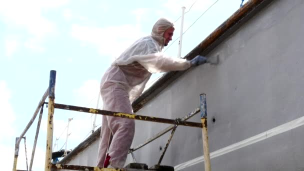 Arbetaren målar med pensel metall framsidan av fartyget på varv i hamnen i Moskva. — Stockvideo