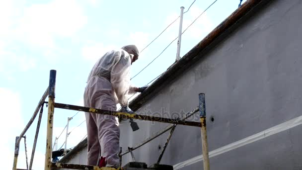 Arbeiter malt mit Pinsel Metallfront des Schiffes auf Werft im Hafen von Moskau. — Stockvideo