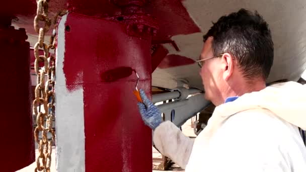 Travailleur peint métal de l'hélice de navire couleur rouge au chantier naval dans le port de Moscou . — Video