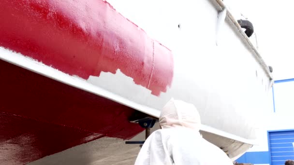 Werknemer schildert rood metaal van een oude roestige schip bij de scheepswerf in haven van Moskou. — Stockvideo