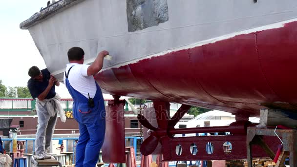 Worker stick an adhesive tape on metal of old rusty ship at shipyard in port. — Stock Video