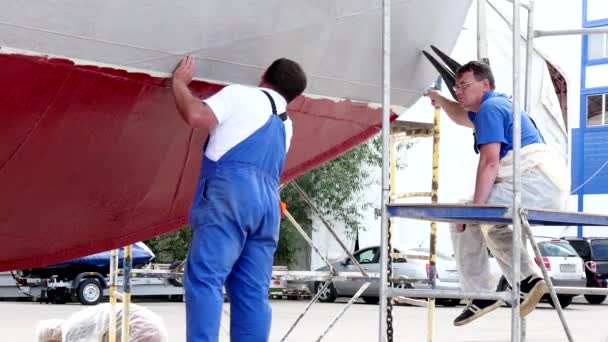 Werknemer opplakken een plakband metaal van een oude roestige schip bij de scheepswerf in haven. — Stockvideo