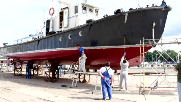 Worker paints metal of ship at shipyard in port of Moscow. — Stock Video