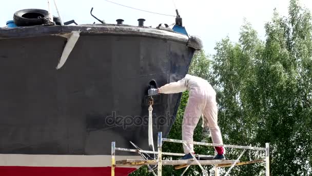 Працівник малює пензля металеві передній частині корабля на верфі в порту Москви. — стокове відео