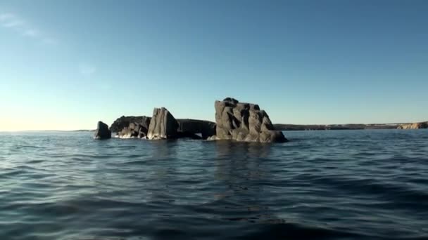 Rocas de piedra entre la superficie acuosa del Océano Ártico en la Nueva Tierra . — Vídeo de stock
