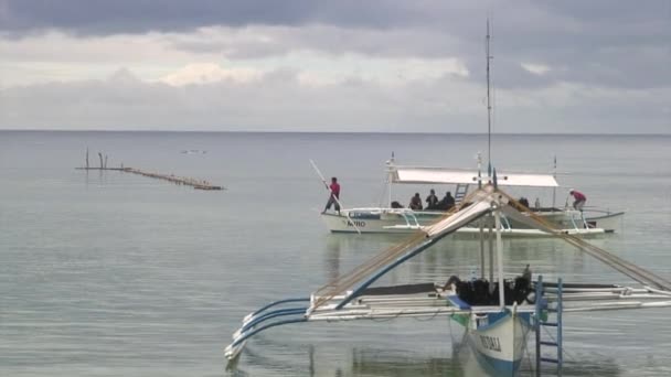 Mensen op de boot op de achtergrond van de groene Pacifische kust in Filippijnen. — Stockvideo