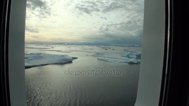 Ice and iceberg from porthole window of yacht in Arctic Ocean. — Stock Video