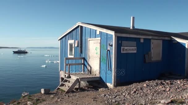 Hus i berg på bakgrund av båtar på stranden av Arktiska oceanen i Grönland. — Stockvideo