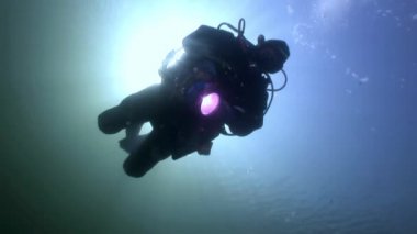Scuba diver siluet feneri arka plan yansıması güneş ışığı su altında.