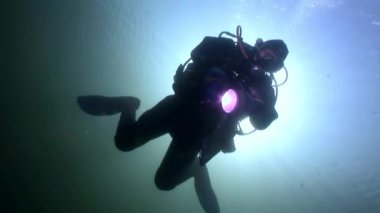 Scuba diver siluet feneri arka plan yansıması güneş ışığı su altında.