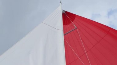 Yat ve tekne gökyüzünde bulutlar arka plan üzerinde beyaz ve kırmızı yelkenlerini.