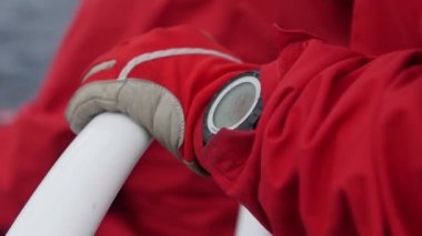 Kırmızı elbiseler tulum ile giyim eşyası aygıt Yatlar Küpeşte üzerinde işçi el.