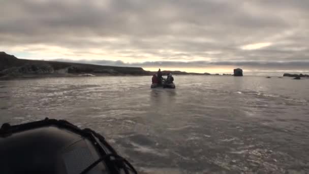 La gente en barco navega en el fondo de las montañas y el desierto en el Océano Ártico  . — Vídeo de stock