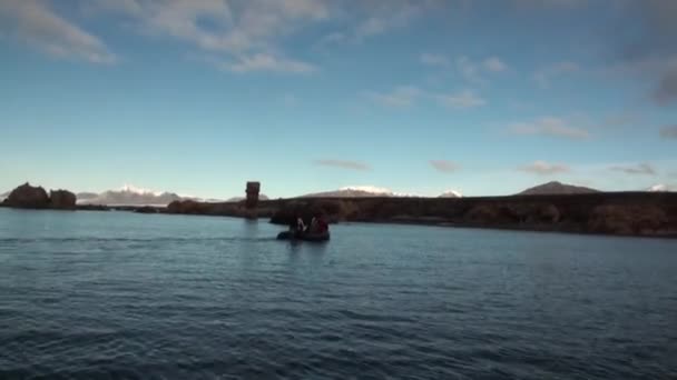 Le persone in barca navigano sullo sfondo delle montagne e del deserto nell'Oceano Artico  . — Video Stock