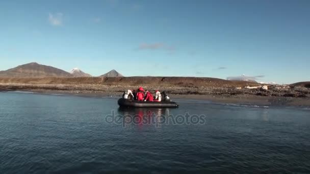 人がボートに帆の背景の山々 と北極海の砂漠 . — ストック動画