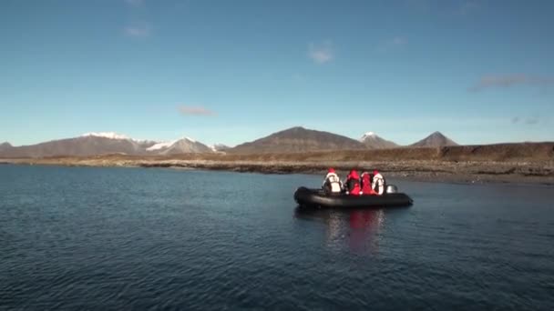 La gente en barco navega en el fondo de las montañas y el desierto en el Océano Ártico  . — Vídeo de stock