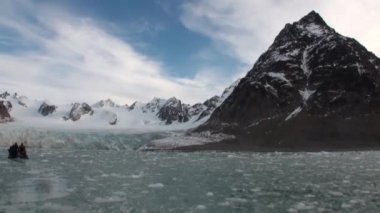 Tekne yelken üzerinde insanlar hareketli buzlar, Kuzey Buz Denizi Svalbard içinde arka plan.