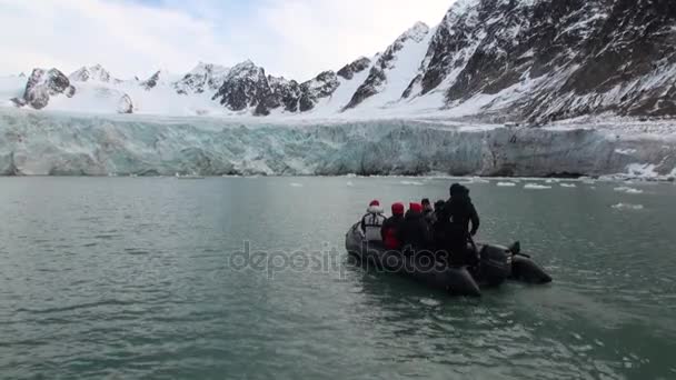 Les gens en bateau naviguent sur fond de montagnes de neige dans l'océan Arctique Svalbard . — Video