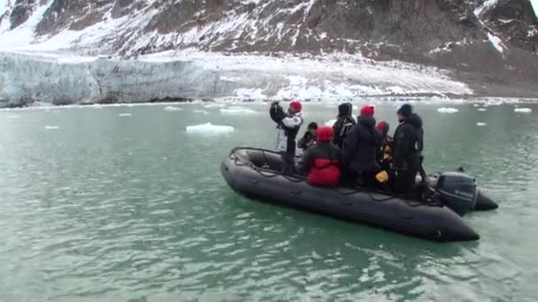 Mensen in boot varen op achtergrond van sneeuw-gebergte in de Noordelijke IJszee Spitsbergen. — Stockvideo