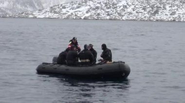 Kuzey Buz Denizi Svalbard dağlarda kar arka plan üzerinde insanlar tekne yelken.