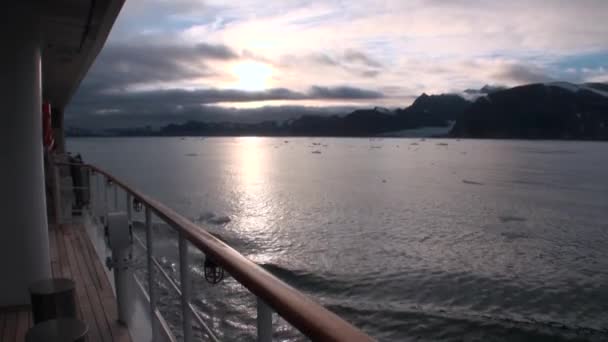 Montagne innevate e riflesso del tramonto sulla superficie dell'acqua vista dal ponte yacht . — Video Stock