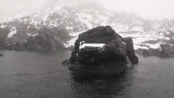 Snö berg och steniga klippor i dimma av Arktiska oceanen i Svalbard. — Stockvideo