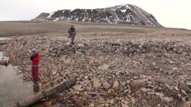 Emberek, háttérben a havas hegyek, a Jeges-tenger Svalbard. — Stock videók