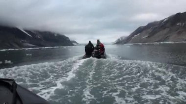 Tekne yelken üzerinde insanlar hareketli buzlar, Kuzey Buz Denizi Svalbard içinde arka plan.