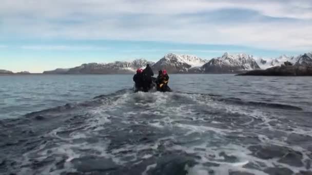 La gente en barco navega en el fondo de las montañas de nieve en el Océano Ártico Svalbard . — Vídeos de Stock