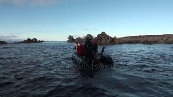 人在小船航行在山脉的北冰洋斯瓦尔巴群岛的背景. — 图库视频影像