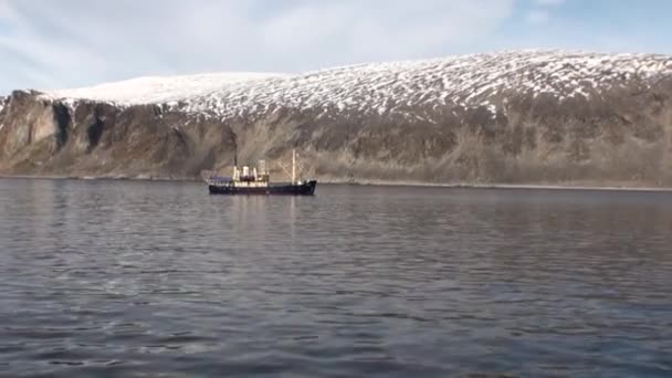 Navire et surface de l'eau sur fond de côte enneigée dans l'océan Arctique . — Video