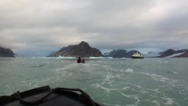 Lidé v lodní plachty a velké jachty na pozadí zasněžených hor v Arktidě. — Stock video