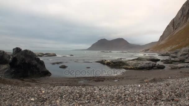 Costa do deserto e ondas do Oceano Ártico no fundo das montanhas em Svalbard . — Vídeo de Stock