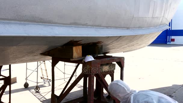 Trabajador pinta metal de viejo barco oxidado en el astillero en el puerto de Moscú . — Vídeo de stock