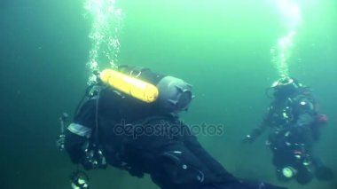 Yansıma güneş ışığı su altında arka plan üzerinde iki dalgıç.