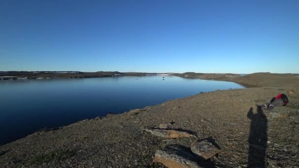 Mężczyźni na wybrzeżu i wody powierzchni Oceanu Arktycznego na ziemi nowej Wajgacz. — Wideo stockowe