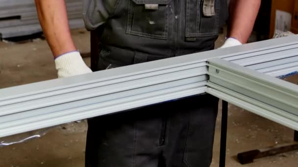 Worker cuts with scissors sealant for plastic windows from aluminum profile. — Stock Video