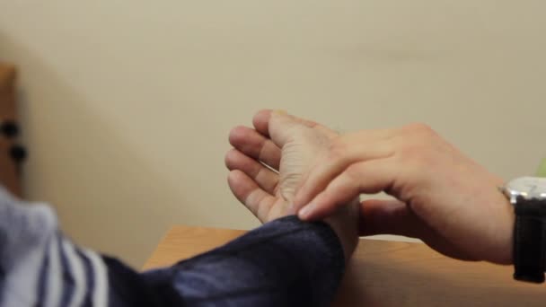 Ręka lekarza z zegarem sprawdza puls pacjenta w klinice. — Wideo stockowe