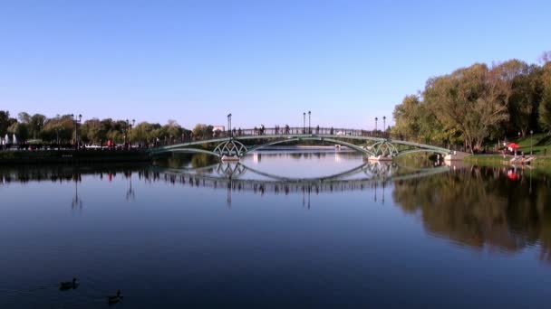 People go across bridge near fountains in park in summer Moscow. — Stock Video
