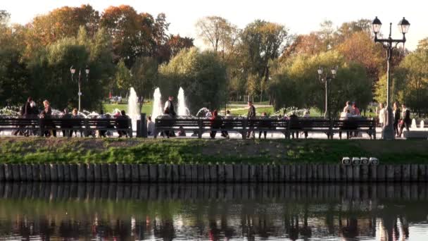 Люди в парку на лавці поруч фонтани влітку в Москві. — стокове відео