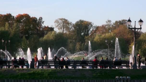 Menschen im Park auf Bank in der Nähe von Brunnen im Sommer in Moskau. — Stockvideo