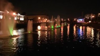 Nehirde parlayan fıskiyeler ve gece Moskova 'da köprü arka planında fenerler.