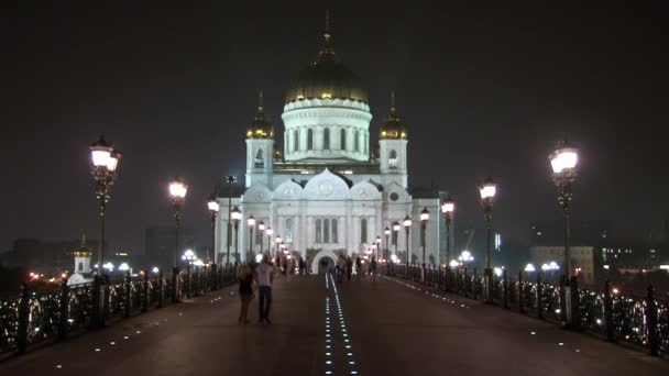 Mensen lopen langs patriarchaal brug naar de kathedraal van Christus Verlosser in Moskou. — Stockvideo